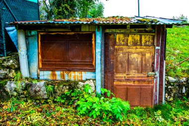 İtalya, Veneto 'daki Chiampo Vadisi' ndeki çayırların arasında paslı bir metal kulübe.