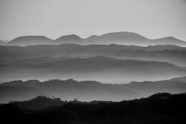 panorama of the Venetian hills among the mists of the plain taken from the pre-alps above Valdagno, Vicenza, Italy