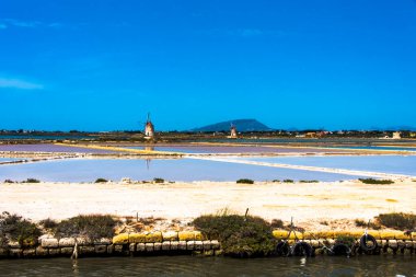 Marsala Trapani Sicilya İtalya 'da eski yel değirmenleri ve tuz bataklıklarıyla Stagnone lagünündeki Saline di Marsala.