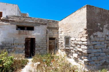 Trapani Sicilya 'daki Favignana Adası' nda güneş yanığı çimen tuğlalı ve açık ahşap kapılı terk edilmiş mimarlık evi.