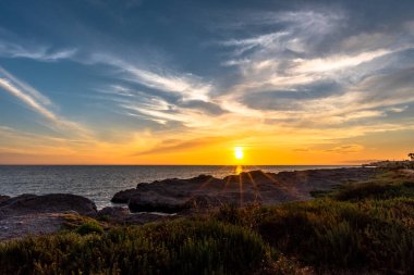 Marsala Trapani Sicilya 'da kayalar ve deniz arasında gün batımı