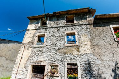 İtalya 'nın Vicenza Veneto bölgesindeki Lessini dağlarının pencerelerinden dışarı bakan bulutlarla harap olmuş bir ev.