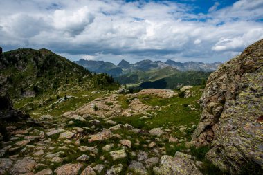Lagorai Dağları 'ndaki Rocky Alp Platosu, Trentino, İtalya, uzak tepeler, yeşil yamaçlar ve dramatik yaz bulutları