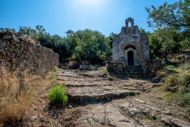 Corte, Corsica, Fransa yakınlarındaki kırsal bir yol boyunca demir haçlı taş şapeli. Akdeniz ormanlarında geçen tarihi mimari, miras, inanç ve yavaş seyahat kavramları için idealdir..