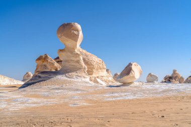 Mısır 'ın Giza yakınlarındaki kumlu çölden yükselen belirgin kireç taşı şekilli mantar oluşumu erozyon, jeoloji ve gerçeküstü çöl manzarası sergiliyor..