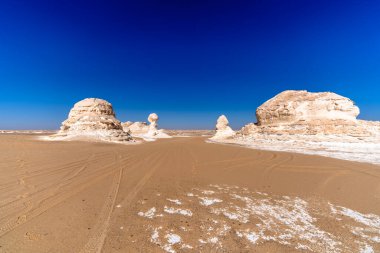 Mısır 'ın Giza yakınlarındaki büyük kireçtaşı oluşumları tarafından çerçevelenmiş doğal kumlu geçit derinlik, simetri ve güçlü bir keşif hissi yaratıyor..