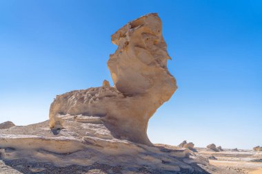 Mısır 'ın Giza yakınlarındaki Beyaz Çölün kumlu zemininden yükselen ıssız kireçtaşı kayaları rüzgar şeklindeki dokuları ve aşırı çöl ortamını vurguluyor..