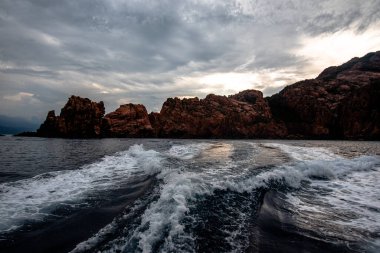 Fransa 'nın L' le-Rousse şehrinde dağlık kıyı şeridi ve dağınık bulutları olan mavi bir körfeze bakan kayalık manzarası. Seyahat, doğa ve kıyı manzarası temaları için.