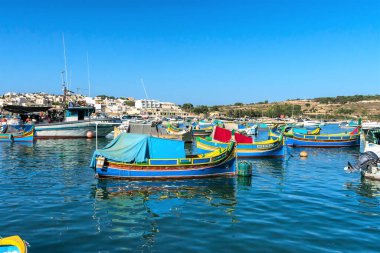 Malta, Marsaxlokk, Ağustos 2020. Körfezin mavi sularında geleneksel balıkçı tekneleri.