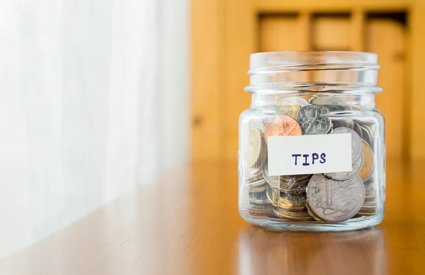 Glass bank for tips with money — Stock Photo, Image