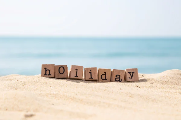 Vakantie seizoen woord met zonnige strand en de oceaan achtergrond — Stockfoto