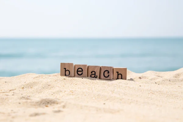 Strand woord over zee met blauwe oceaan achtergrond — Stockfoto