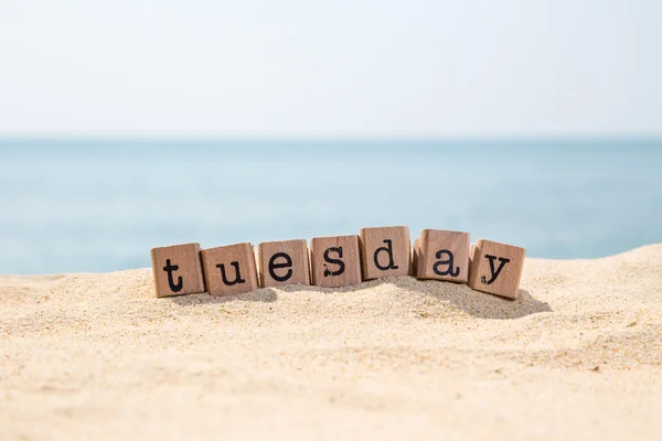 Tuesday word on sea beach — Stock Photo, Image