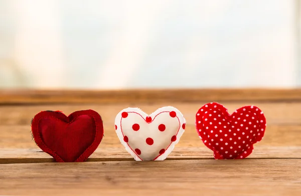 Tono rojo lindo corazones artesanía hecha a mano en la superficie de madera — Foto de Stock