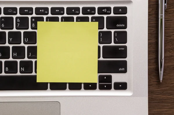Yellow blank paper note on laptop keyboard — Stock Photo, Image