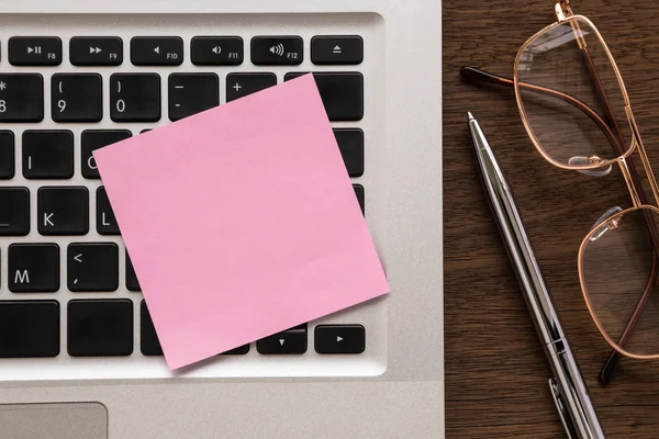 Papel blanco rosa en el ordenador portátil para la nota — Foto de Stock