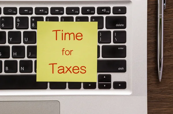 Kladblok met woorden "T─│d voor belastingen" zetten op laptop — Stockfoto