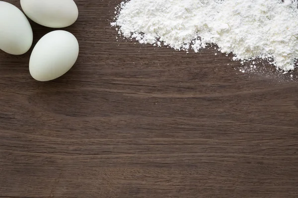 Пекарный фон, яйца и мука на столе — стоковое фото