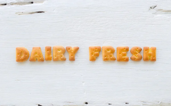 Word DAIRY FRESH Alphabet cookies on wood fone — стоковое фото