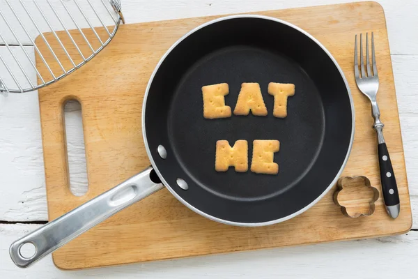 Lettera biscotti parola MANGIARE ME e utensili da cucina . — Foto Stock