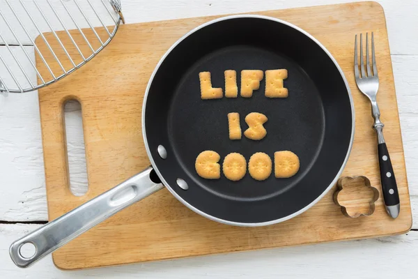 Letter cookies quote LIFE IS GOOD and kitchen utensils — Stock Photo, Image