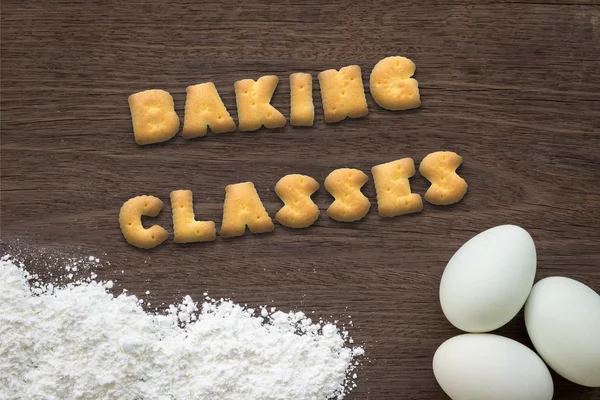 Letter biscuits word BAKING CLASSES  on kitchen table background — Stock Photo, Image