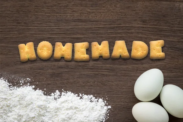 Alphabet cookies mot HOMEMADE sur fond de table de cuisson — Photo