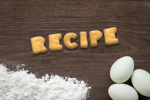 Alphabet cookies word RECIPE on cooking table background — Stock Photo, Image