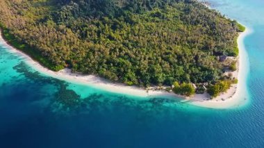 Yüksek irtifada uçan İHA sakin tropikal okyanus ve sığ turkuaz sularla çevrili Sikandang Adası 'nın tepesini yakalıyor..