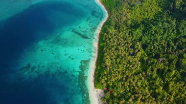 İHA görüntüsü Sikandang Adası 'nın bir kısmını ve etrafındaki denizi gösteriyor. İnsansız hava aracı yükseliyor ve geriye doğru uçuyor..