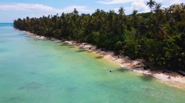 Sikandang Adası 'nın yanındaki turkuaz deniz üzerinde uçan İHA, verimli tropikal bitki örtüsü, kumlu plajlar ve Endonezya' nın berrak kıyı sularını ortaya çıkarıyor..