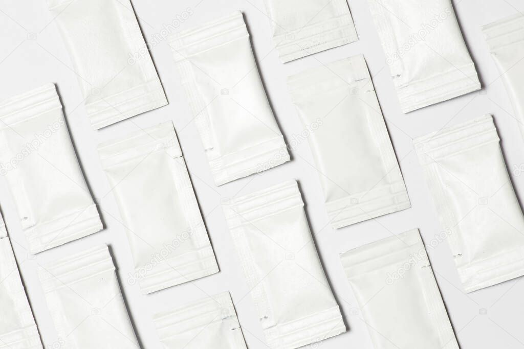 Close-up composition of white sachets on a white background.