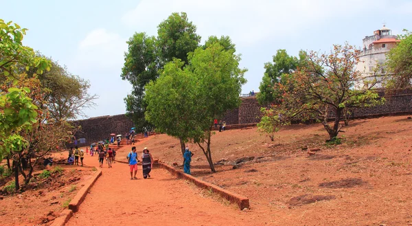 CANDOLIM, GOA, INDIA - 11 APR 2015: Unidentified tourists walk near Fort Aguada, Goa. — Stock Photo, Image