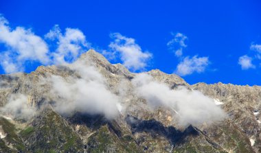 Clouds in the snowy mountains in Himalayas. clipart