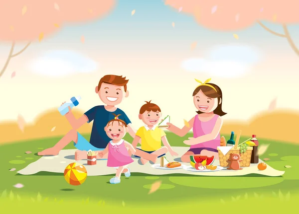 Aile pikniği seviyor. Parktaki çimlerin üzerinde oturuyorlar, içinde çocuklar için yemek ve oyuncaklar olan sepette. Bulanık arkaplan.