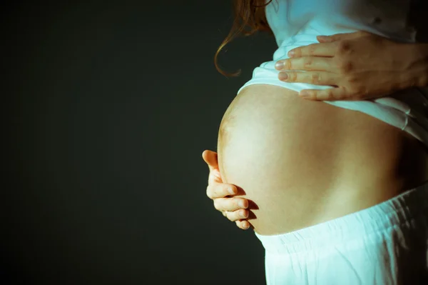 Bild einer schwangeren Frau, die ihren Bauch mit den Händen berührt — Stockfoto