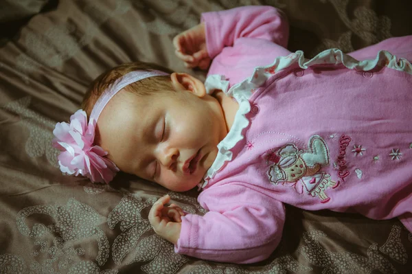 Bild von niedlichen kleinen Mädchen in rosa Anzug drinnen. Neugeborenes Baby — Stockfoto