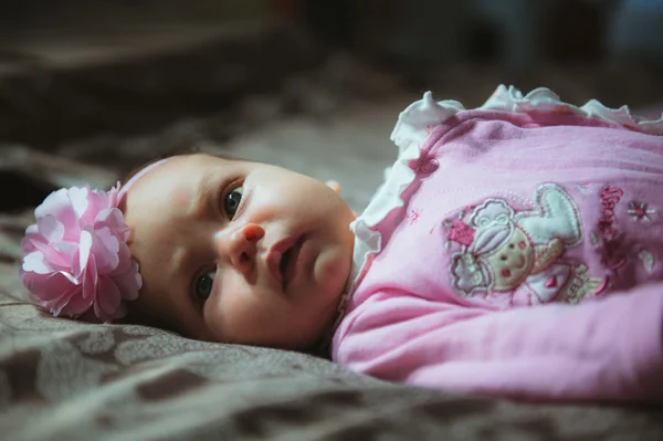 Изображение милой маленькой девочки в розовом костюме внутри. Новорожденный — стоковое фото