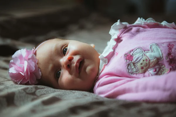 Image of cute little girl in pink suit indoor. Newborn baby — Stock Photo, Image