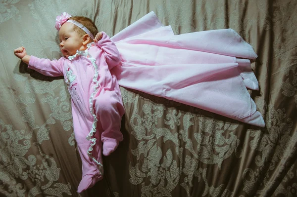 Image of cute little girl in pink suit and cloak indoor