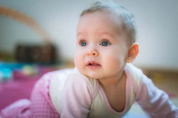 Schattige baby meisje verkenningen op all fours verdieping thuis. Glimlachen — Stockfoto