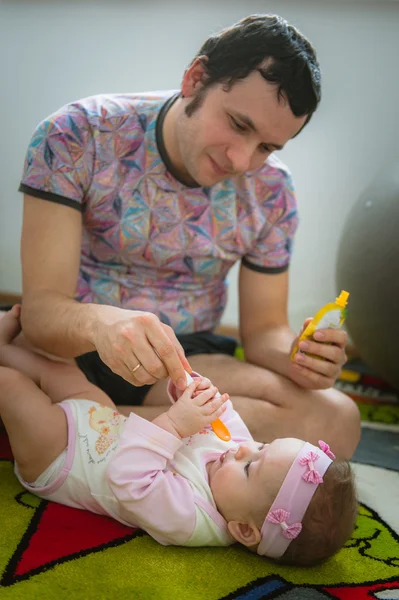 Papa füttert Kind mit Löffel. Bild des jungen Vaters — Stockfoto