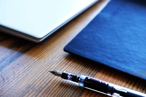 dizüstü bilgisayar, defter ve dolmakalem tahta masa üzerinde - seçici odak konsepti fotoğrafı
