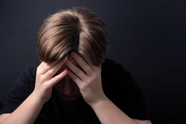 Kapalı bir pozisyonda oturan genç, COVID-19 tecridi sırasında depresyon gibi zihinsel sağlık sorunları yaşıyor