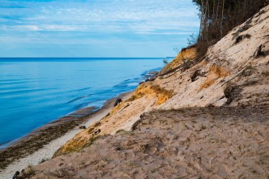 Baltic sea landscape with golden sand dune and calm water without waves