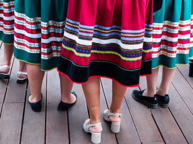 Polonya 'da bir folklor grubundaki kadınlar renkli çizgili etek giyiyorlar.