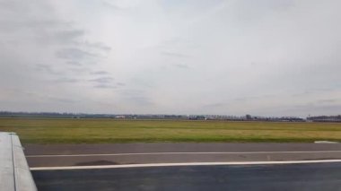Schiphol 'da soğuk bir kış sabahında, puslu Hollanda manzarasına bakan bir uçak penceresinden manzarayı izliyoruz.