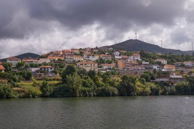 Douro Nehri Vadisi 'nde arka planda rüzgar türbinleri olan küçük bir köy, Portekiz