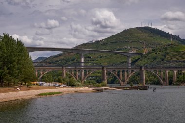 Demir Köprü - Douro Nehri Vadisi 'ndeki Cruise Boat' un manzarası - Portekiz 'in Pinho şehrinde dağlarda oyulmuş Çiftlik Terasları ile birlikte Port Şarap Bölgesi