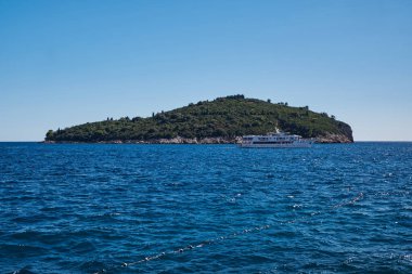 Mavi Adriyatik Denizi üzerindeki Yeşil Lokrum Adası 'nı geçen Beyaz Feribot - Dubrovnik, Hırvatistan